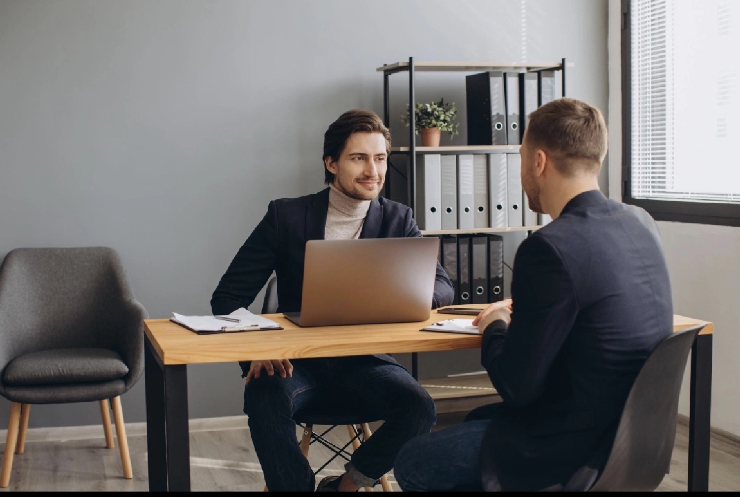 Pferdehirt People & Talent Consulting UG (haftungsbeschränkt) – zwei Personen in einer professionellen Büroumgebung, wahrscheinlich während eines Vorstellungsgesprächs oder eines Geschäftstreffens.